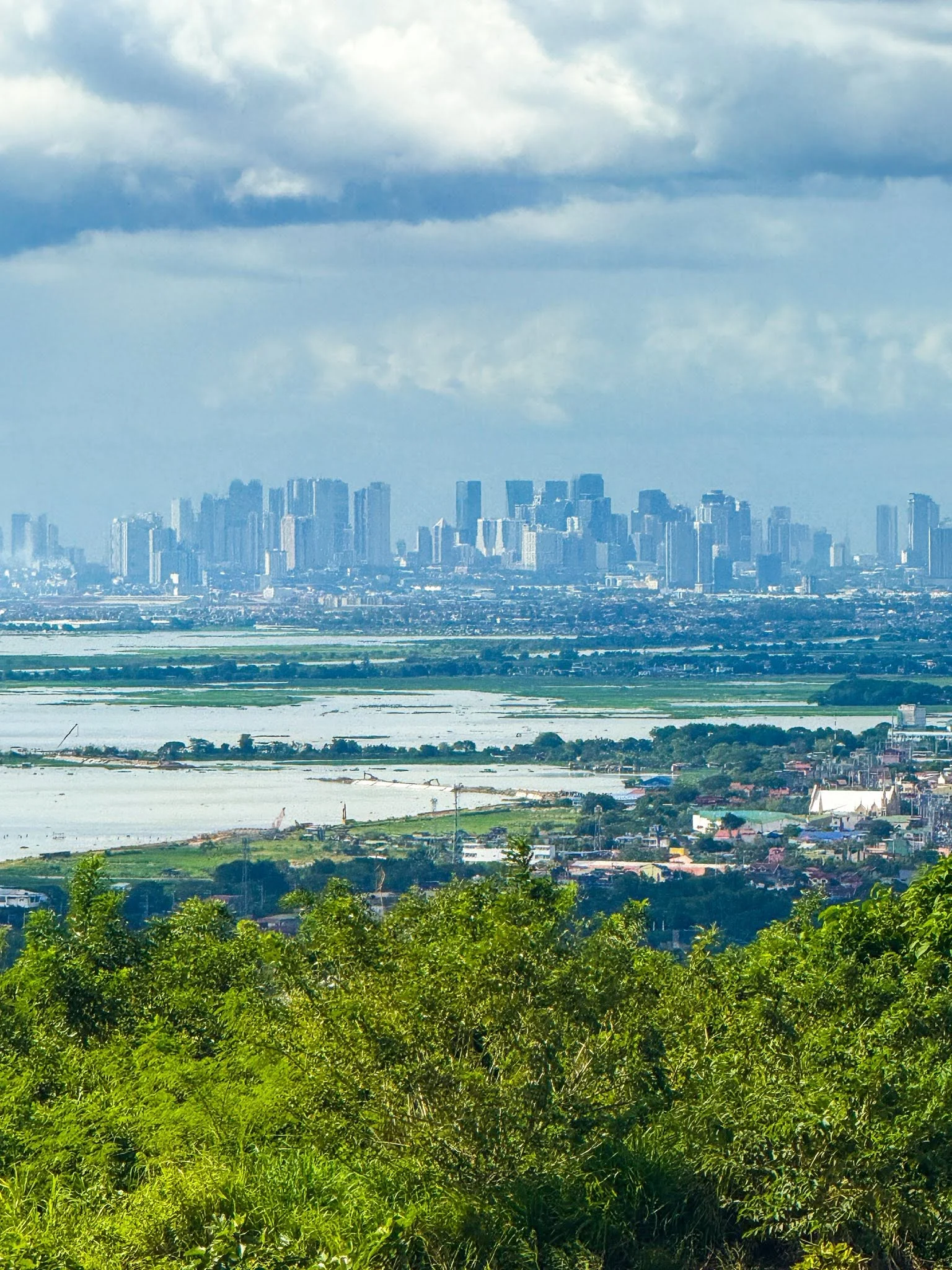 The distant city skyline beyond the water and green hillside at City on a Hill