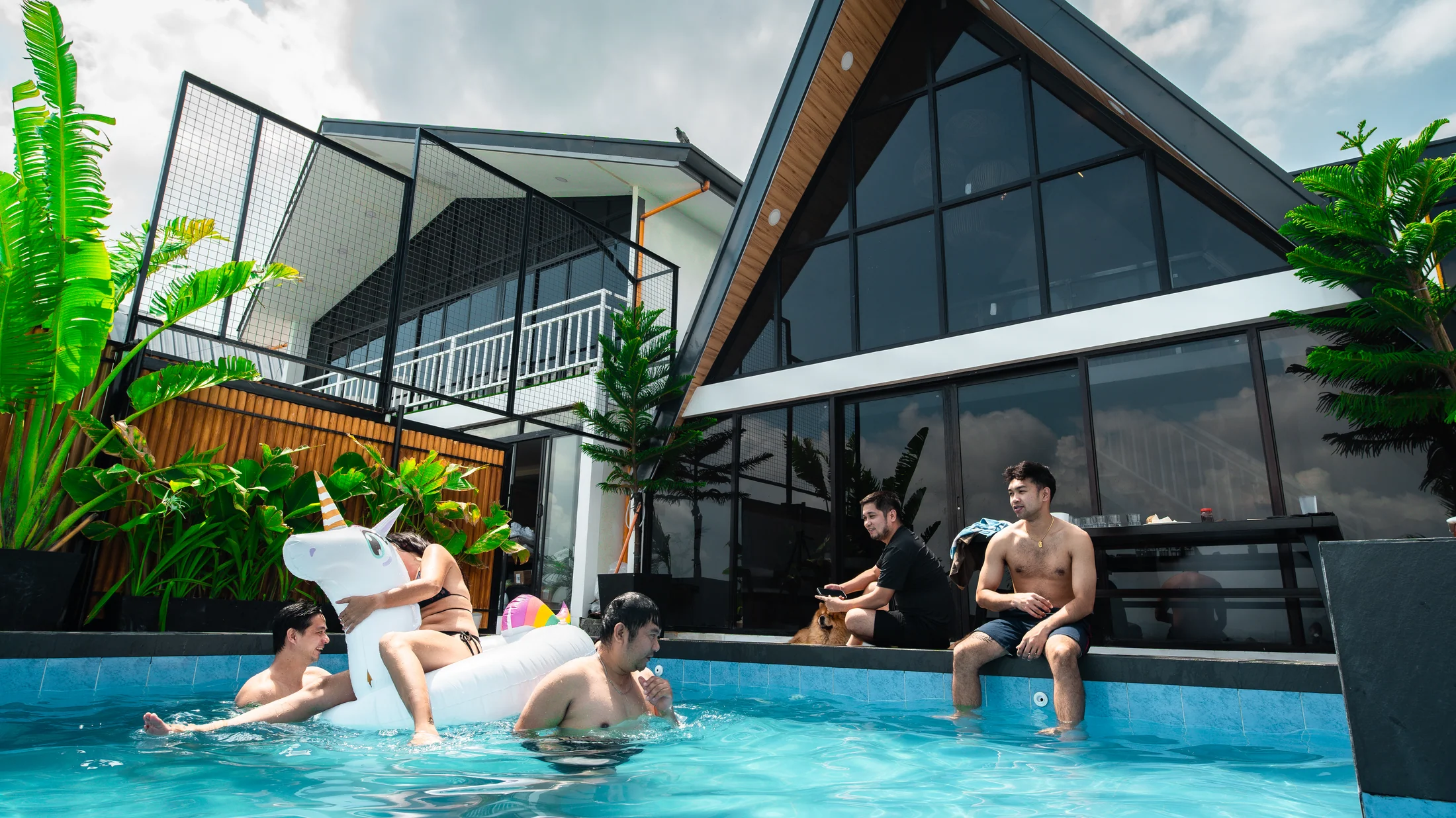 Friends relaxing by a private villa pool at City on a Hill, Binangonan