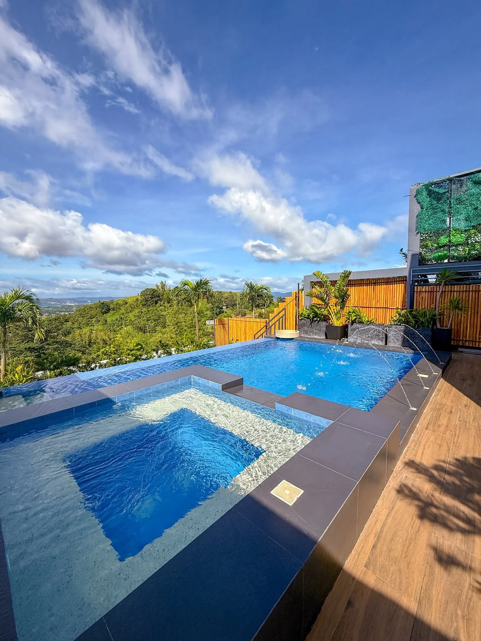 A blue pool and wooden terrace with hillside views at City on a Hill