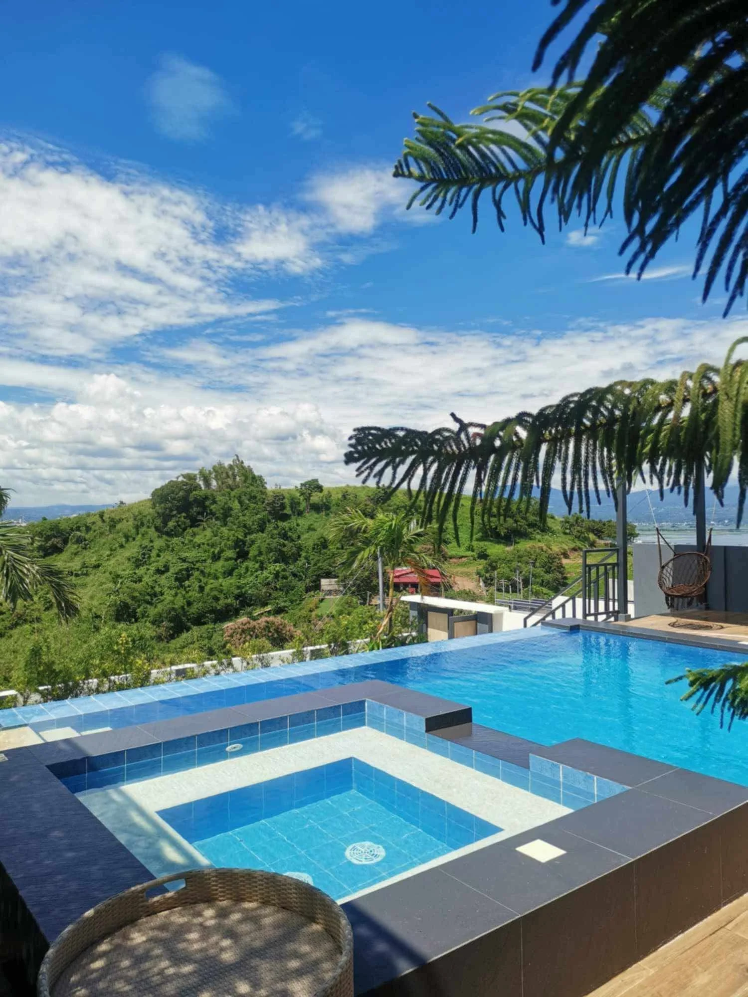 A sunlit pool and its smaller adjoining water area beside a wooden deck at City on a Hill