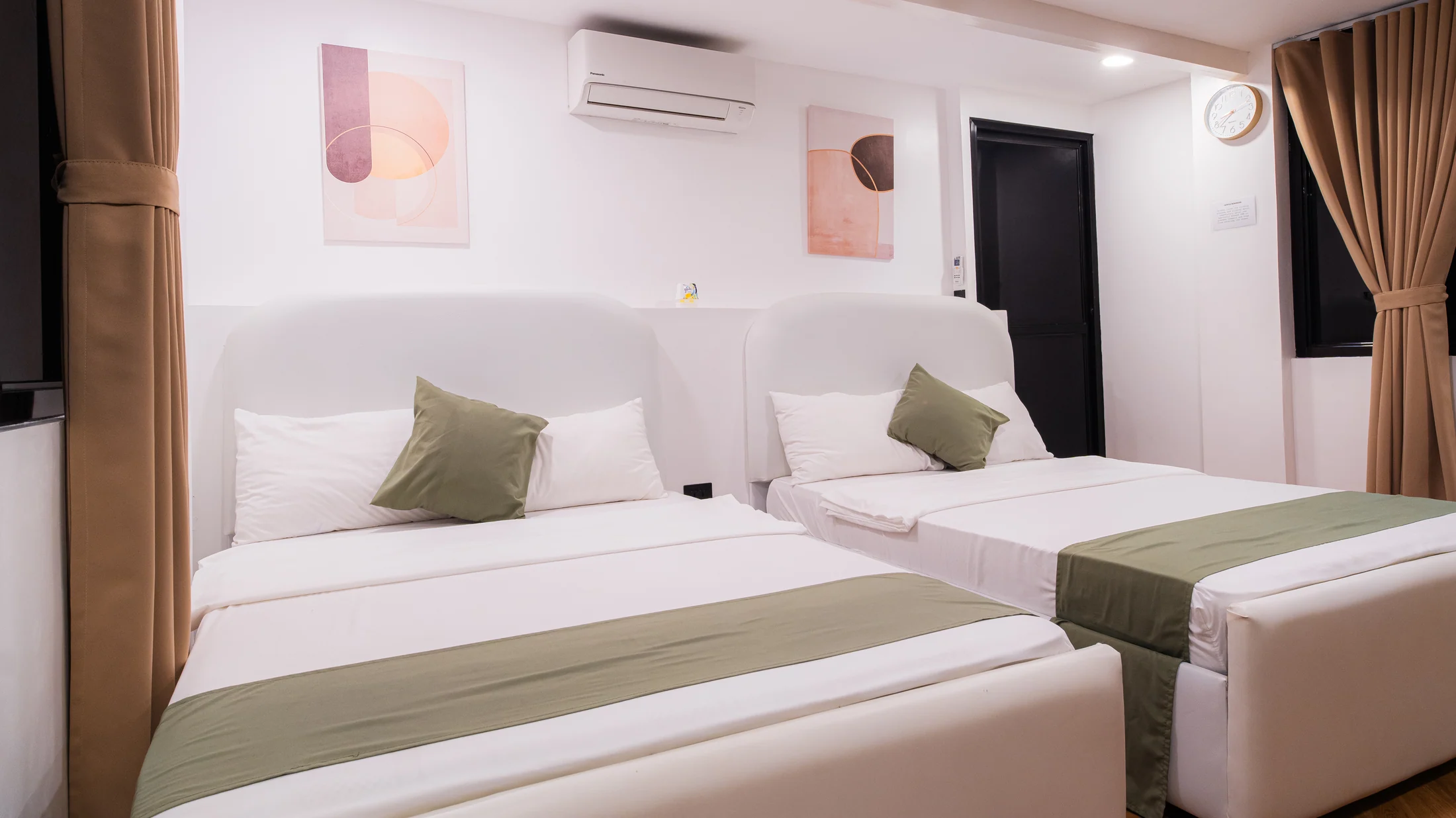 A bedroom with white beds, soft curtains and a small seating area at City on a Hill