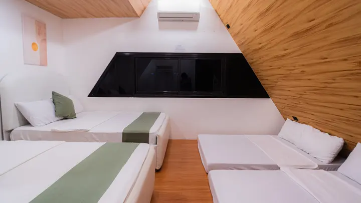 Two double beds and two floor mattresses under the timber slope.
