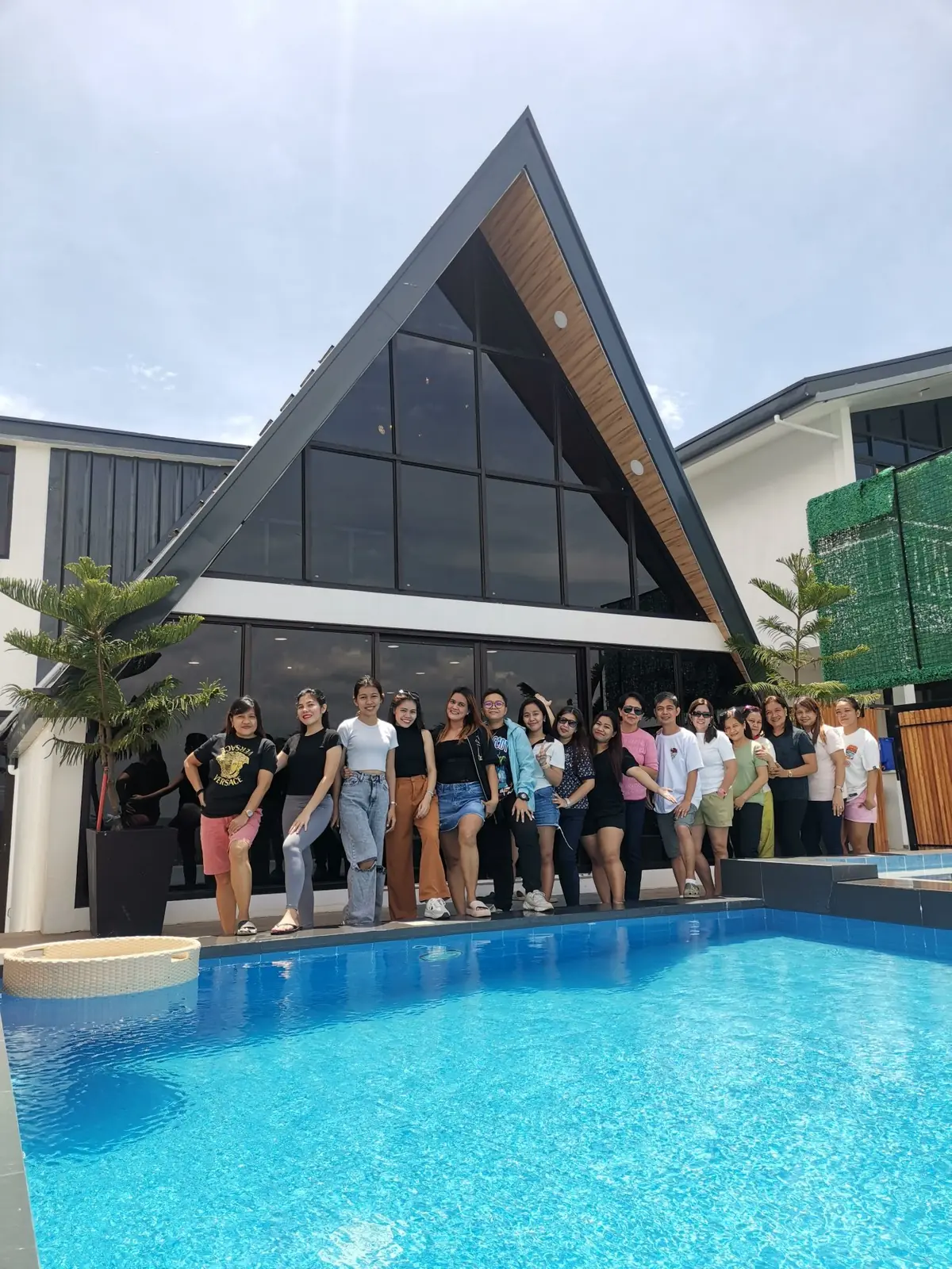 A group of guests by the pool in front of Zachary’s glass A-frame.
