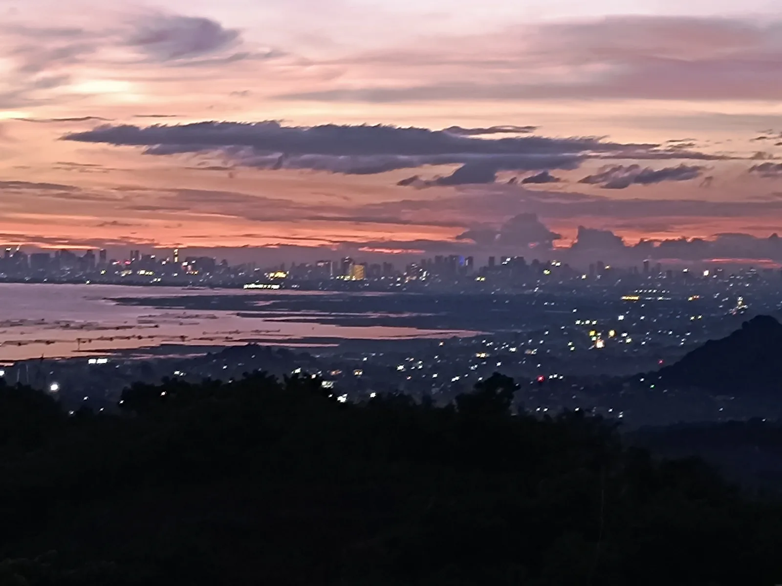 City lights coming on across Metro Manila at nightfall, seen from Binangonan, Rizal
