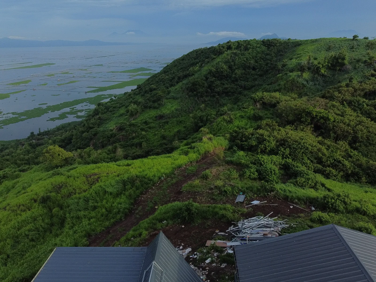 Green hills and Laguna Lake seen from behind the villa rooftops at City on a Hill