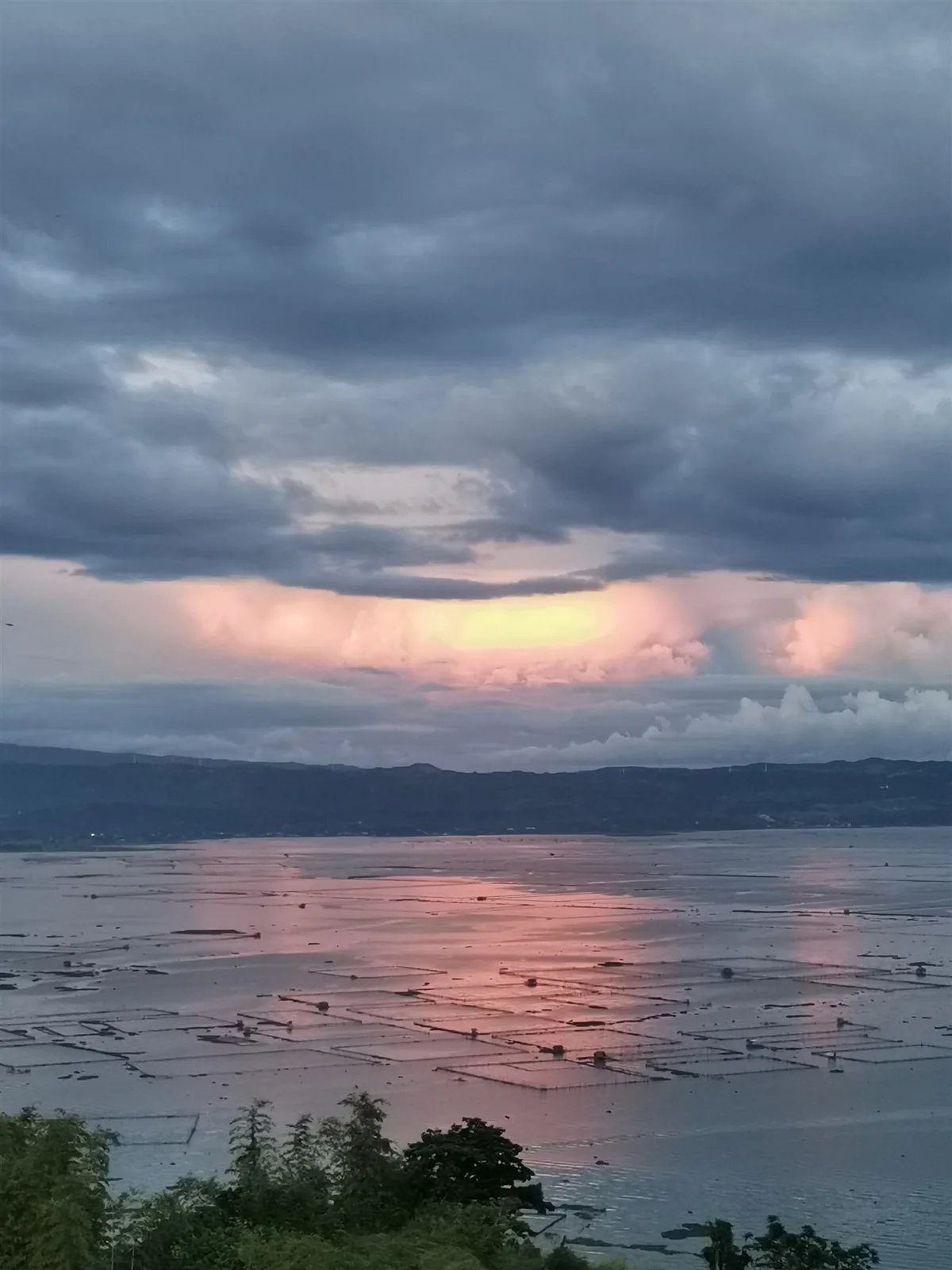 Pink morning clouds over Laguna Lake seen from the hillside in Binangonan